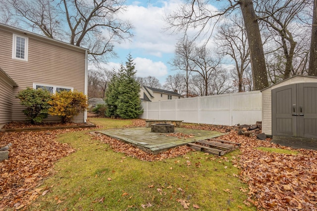 view of yard featuring a storage unit, a patio, and an outdoor fire pit