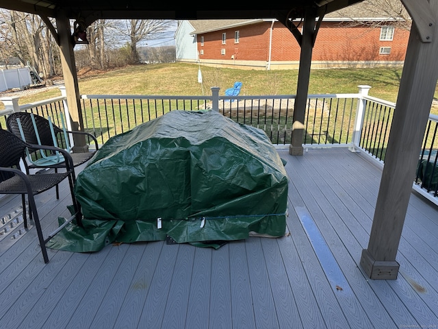 wooden deck featuring a lawn