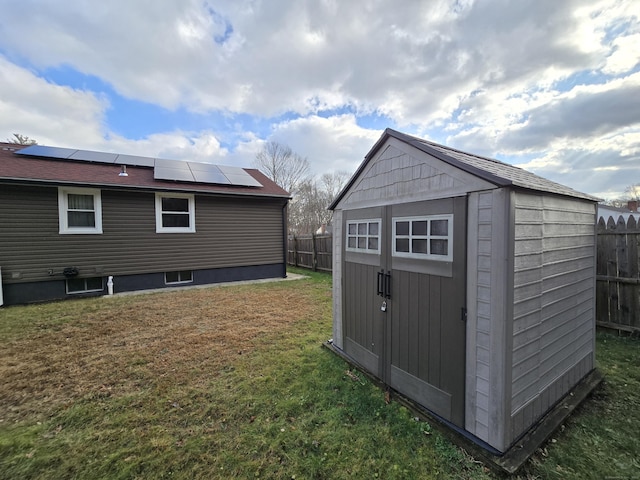 view of outbuilding with solar panels and a yard