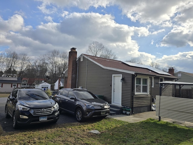 exterior space featuring solar panels and a front lawn