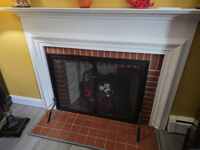 room details featuring a fireplace and a baseboard radiator