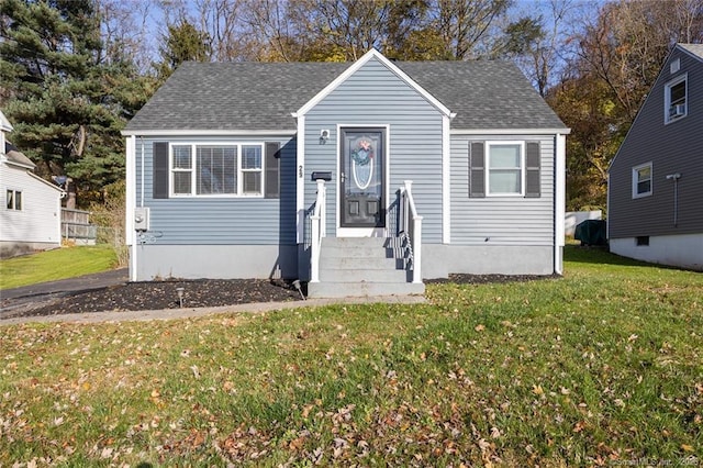 bungalow-style house with a shingled roof and a front yard