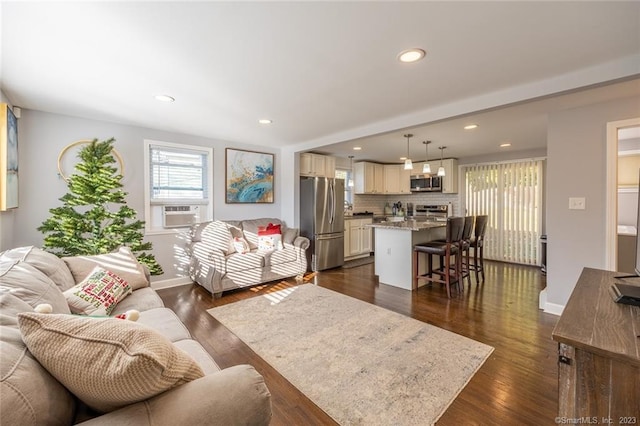 living area with baseboards, cooling unit, dark wood-type flooring, and recessed lighting