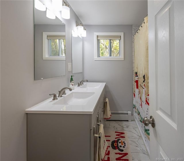 bathroom with marble finish floor, plenty of natural light, baseboard heating, and a sink