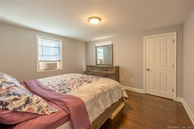 bedroom with dark wood-style floors, baseboards, and cooling unit