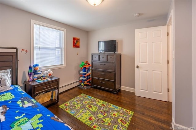 bedroom with a baseboard heating unit, baseboards, and dark wood-style floors