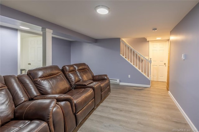 living room with baseboards, stairway, baseboard heating, and light wood-style floors