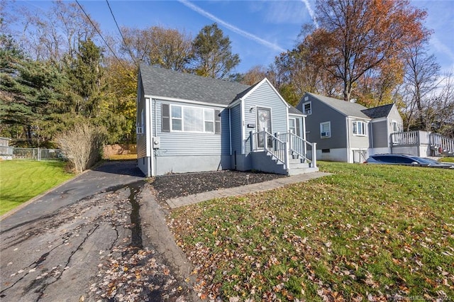 bungalow-style home featuring fence and a front lawn