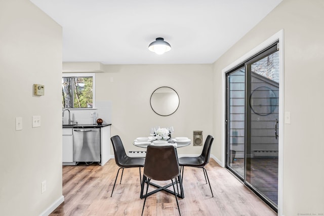 dining area with sink and light hardwood / wood-style flooring