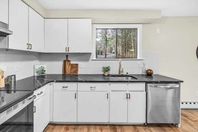 kitchen with decorative backsplash, stainless steel appliances, a baseboard heating unit, sink, and white cabinets