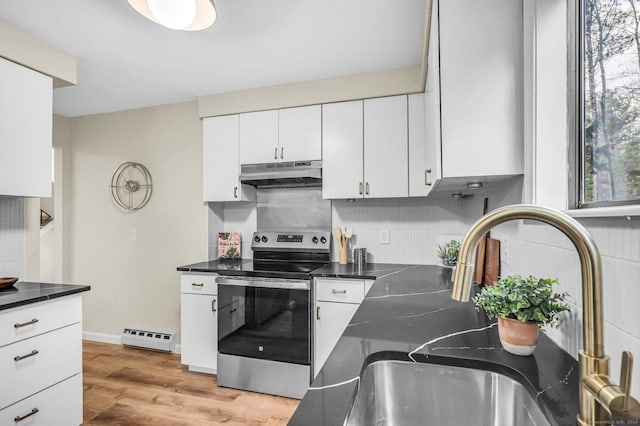 kitchen with electric range, a baseboard radiator, light hardwood / wood-style flooring, decorative backsplash, and white cabinets