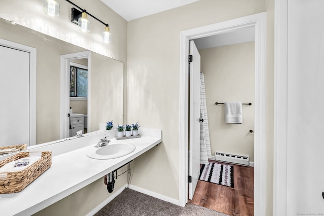 bathroom with a baseboard heating unit and sink