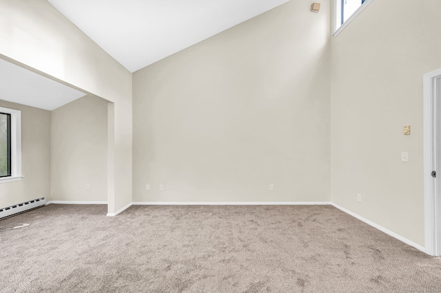 carpeted empty room with baseboard heating and vaulted ceiling