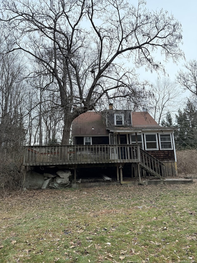 rear view of house featuring a yard and a wooden deck