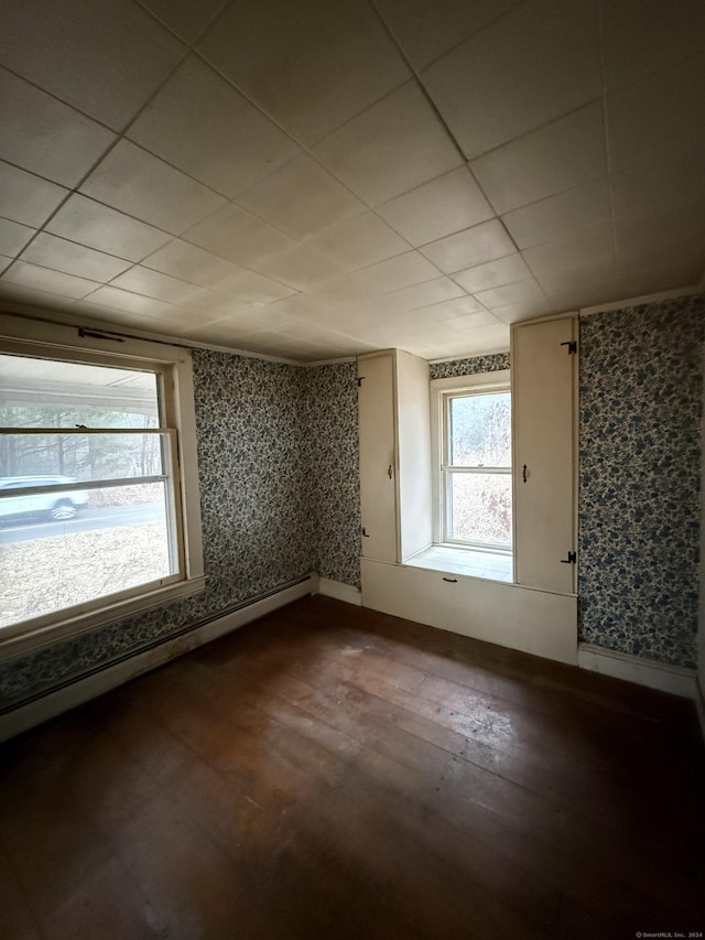 bonus room with wood-type flooring and a baseboard heating unit