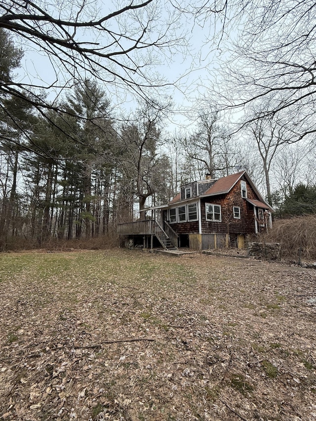 rear view of property featuring a wooden deck