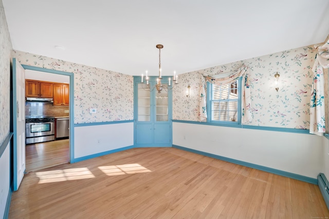 unfurnished dining area with light hardwood / wood-style floors, an inviting chandelier, and baseboard heating