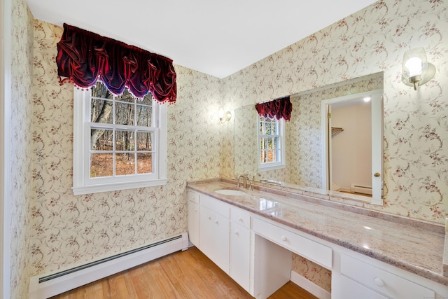 bathroom with hardwood / wood-style floors, vanity, and baseboard heating