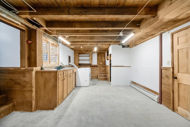 basement with wooden ceiling, a baseboard radiator, and washer / dryer