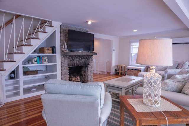 living room with dark hardwood / wood-style flooring, a fireplace, and a wall unit AC