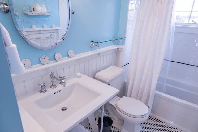 full bathroom featuring shower / bath combo with shower curtain, sink, tile patterned flooring, and toilet