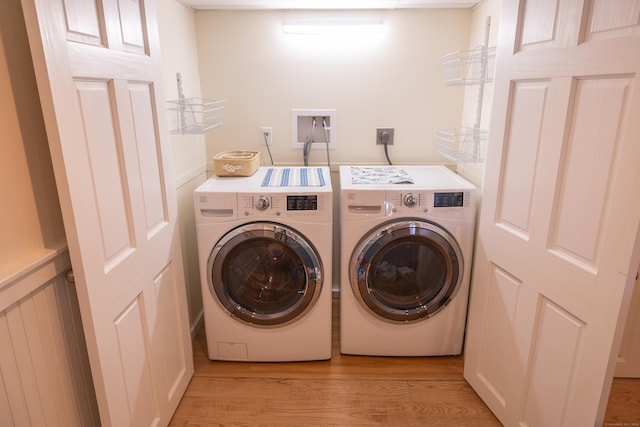 clothes washing area featuring washing machine and dryer and light hardwood / wood-style flooring