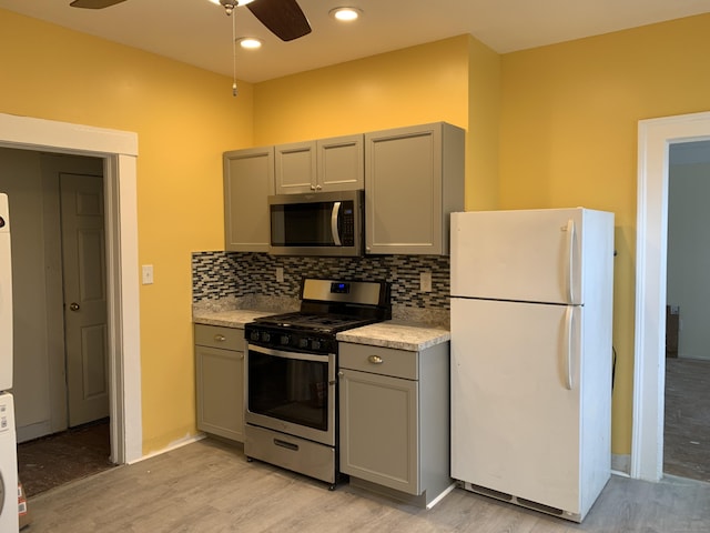 kitchen with light wood-type flooring, stainless steel appliances, and gray cabinets