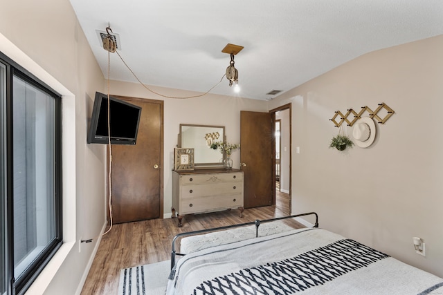 bedroom featuring hardwood / wood-style floors and lofted ceiling