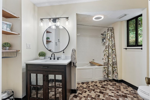 full bathroom featuring vanity, toilet, a textured ceiling, and shower / tub combo