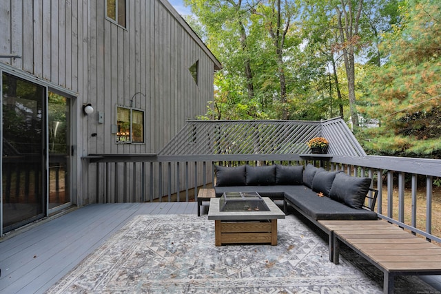 wooden terrace with an outdoor living space with a fire pit