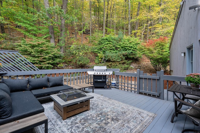 deck with an outdoor living space with a fire pit and a grill