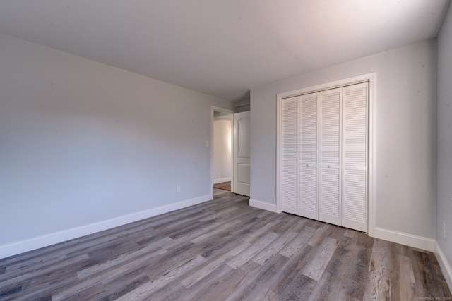 unfurnished bedroom with light hardwood / wood-style floors and a closet