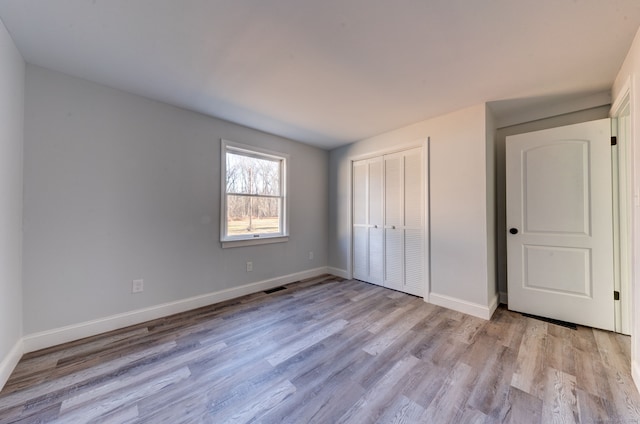 unfurnished bedroom with a closet and light hardwood / wood-style flooring