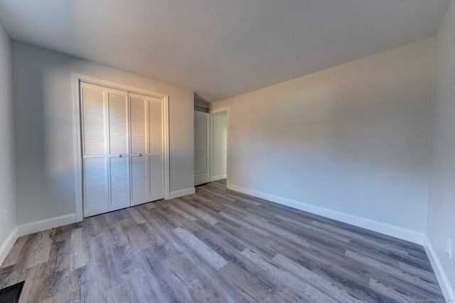 unfurnished bedroom with light hardwood / wood-style floors and a closet