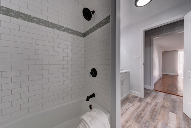 bathroom featuring hardwood / wood-style floors, vanity, and tiled shower / bath combo