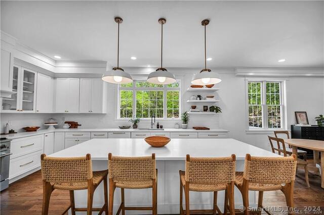 kitchen featuring a center island, a healthy amount of sunlight, pendant lighting, and white cabinetry