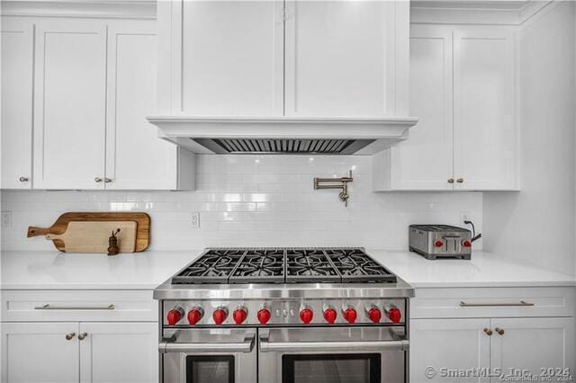 kitchen featuring white cabinets, custom exhaust hood, double oven range, and backsplash