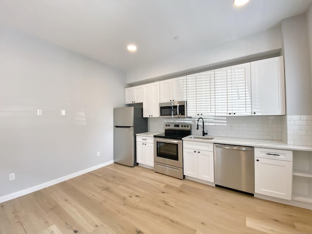 kitchen with white cabinetry, sink, decorative backsplash, and appliances with stainless steel finishes