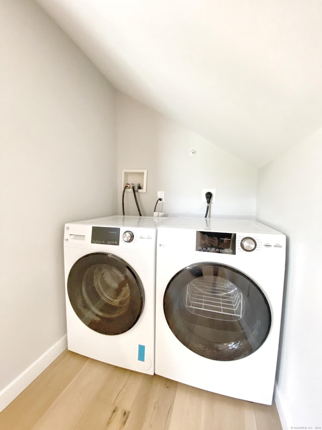 clothes washing area with independent washer and dryer and light hardwood / wood-style floors