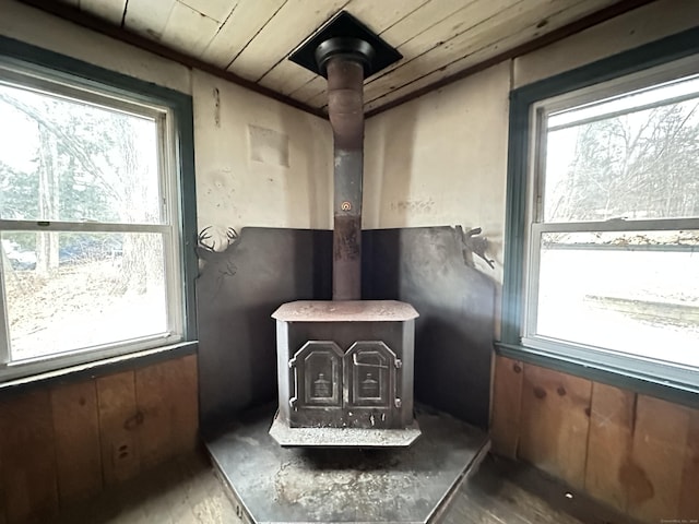 interior details with wood walls, a wood stove, and wooden ceiling