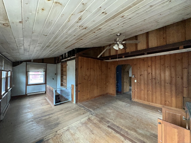 unfurnished room with wood walls, wooden ceiling, vaulted ceiling, hardwood / wood-style flooring, and ceiling fan