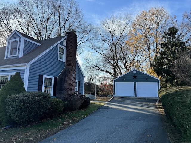 view of side of property featuring an outbuilding and a garage