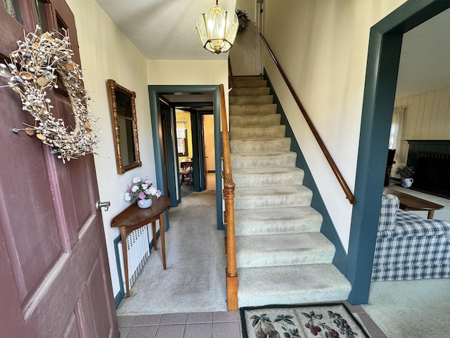 carpeted entrance foyer with a chandelier