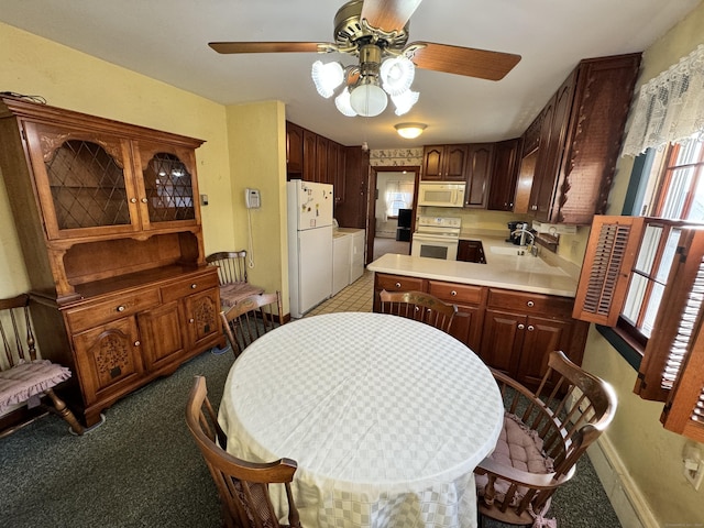 kitchen featuring washer and dryer, light colored carpet, white appliances, and sink