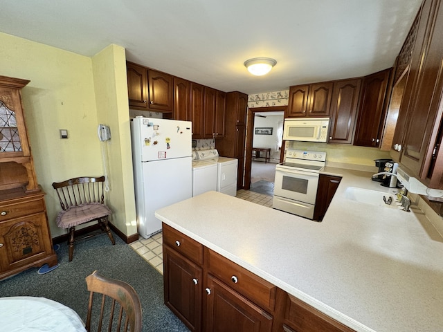 kitchen featuring kitchen peninsula, sink, white appliances, and independent washer and dryer