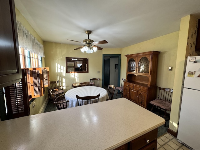 kitchen featuring dark brown cabinets, white refrigerator, and ceiling fan