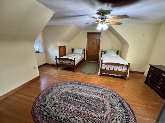 bedroom with ceiling fan, a textured ceiling, and hardwood / wood-style flooring