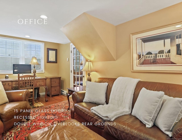 office area with hardwood / wood-style flooring, plenty of natural light, and a baseboard heating unit