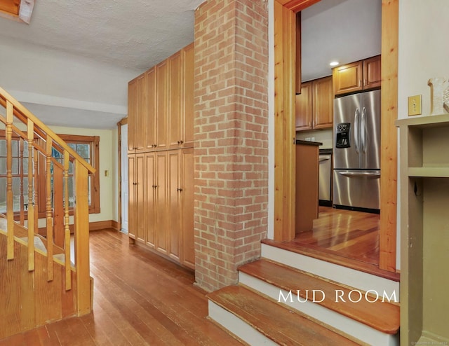 interior space with light hardwood / wood-style flooring, stainless steel appliances, and a textured ceiling