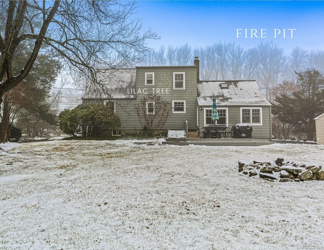 view of snow covered back of property